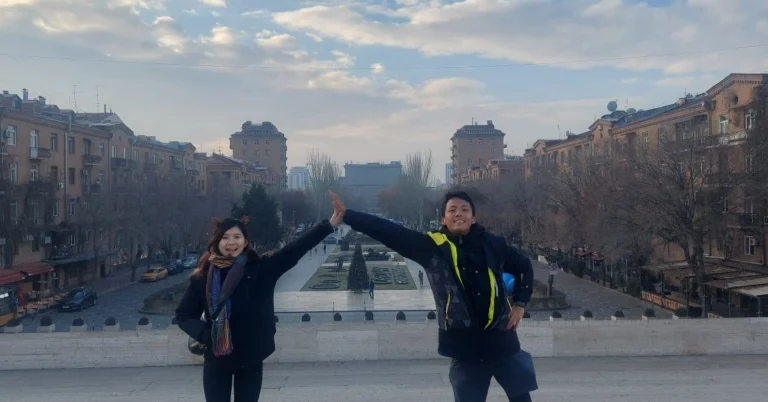 Feature-Page-Things-To-Do-Yerevan with a couple giving five with Yerevan city as backdrop