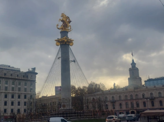 Photo of the bus passing Tbilisi square with statue