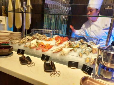 A chef behind a bar of cold seafood