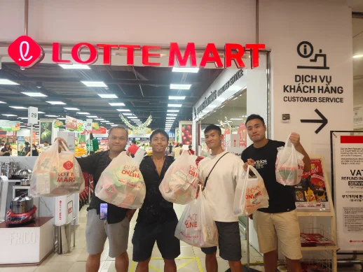 Shopping at Lotte Mart with four men in front taking plastic bags